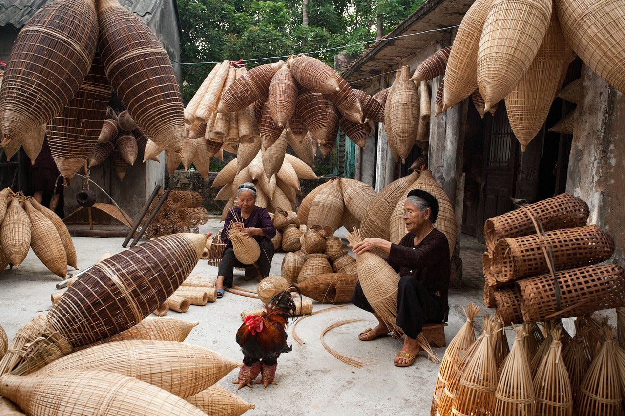 Vietnamese artisans weaving wicker and rattan baskets by hand